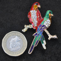 Two enamel/crystal Parrots on perch, A6/11-13